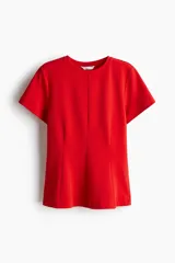 Remera roja entallada de punto interlock pesado, con cuello redondo, mangas cortas, pinzas moldeadoras en la cintura y bajo acampanado.