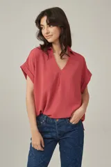Blusa color salmón de viscosa, corte holgado, con cuello camisero y mangas cortas con dobladillo.