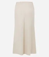 Conjunto color beige compuesto por una falda midi de lino y viscosa con lazo en la cintura y un chaleco sin mangas con botones. Incluye un bolso tote beige.