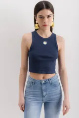 Musculosa gris jaspeado con cuello redondo y bordado de una margarita en el centro.