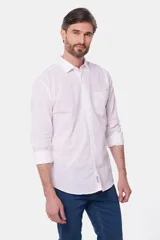 Camisa de lino color beige, de manga larga, con cuello clásico y bolsillo en el pecho.