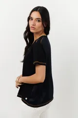 Remera azul marino de algodón con paneles frontales de satén y costuras decorativas en contraste.