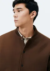 Campera bomber marrón con cierre de botones a presión, cuello mao y bolsillos laterales.