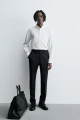 Pantalón de vestir negro de lana, corte recto, con bolsillos laterales y traseros de ojal con botón.
