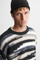 Jersey de hombre con corte relaxed, cuello redondo y manga larga. Diseño con patrón geométrico jacquard en tonos negro, gris y blanco.