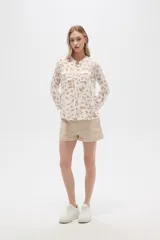 Camisa de viscosa con estampado floral en tonos azul, beige y blanco. Tiene cuello mao, mangas largas y bolsillos en el pecho.