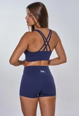 Conjunto deportivo azul marino compuesto por top con breteles anchos y logo blanco en el frente, y short de calce ajustado.