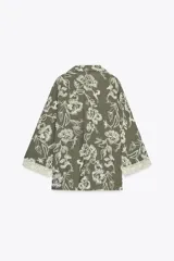 Camisa verde militar con bordado floral blanco, cuello solapa, escote en pico, manga tres cuartos con detalle de guipur y cierre frontal con botones.