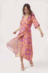 Vestido midi cruzado con estampado floral abstracto en tonos violeta y naranja, con mangas 3/4 abullonadas y lazo ajustable en la cintura. Presenta un tajo lateral.