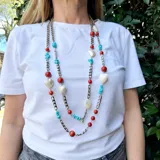 Collar largo con cadena plateada de eslabones y piedras de coral, turquesa y nácar. Incluye dijes en forma de corazón de nácar.