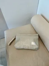 Sobre de mano plateado con detalles en yute y pulsera personalizada con la palabra "RUPIA".