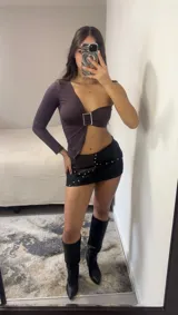 Top asimétrico color marrón con una manga larga, abertura en el abdomen y hebilla metálica.