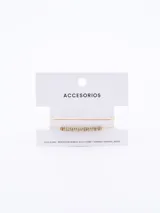 Brazalete dorado con cadena fina y dije con forma de lazo.