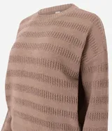 Sweater de punto color beige claro, con textura de rayas horizontales formadas por puntos calados. Presenta cuello redondo, mangas largas y puños y ruedo acanalados.