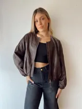 Campera marrón de cuero sintético, corte holgado, con cierre frontal y mangas largas con puños elásticos.