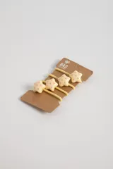 Pack de cuatro gomitas para el pelo con elástico amarillo y apliques de estrellas color crema con lunares rosados.