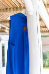 Camisola roja tipo vestido camisero, de corte midi, con cuello camisero, abotonada al frente y con abertura en el ruedo.