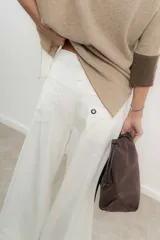 Pantalón marrón de tencel, corte ancho con pinzas y bolsillos laterales.