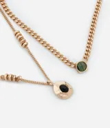Collar de capas dorado con colgantes de resina verde y negra.