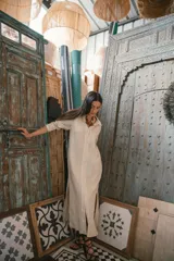 Camisa negra de manga larga con cuello camisero y cierre frontal con botones. Presenta detalles de ribete blanco en cuello, puños y abertura frontal.