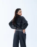 Campera deportiva bomber negra con recortes y vivos blancos.