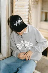 Gorra trucker negra con logo bordado en blanco, de diseñador y materiales de alta calidad.