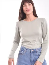 Remera de manga larga color fucsia con cuello redondo y detalle de pequeñas tachas plateadas alrededor del cuello.
