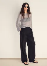 Jersey de punto calado color gris claro, con cuello redondo y manga larga acampanada.