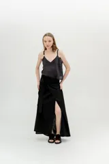 Falda larga negra con abertura lateral y lazo en la cintura.