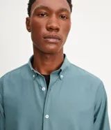 Camisa blanca de algodón, manga larga con botonadura frontal y cuello camisero.