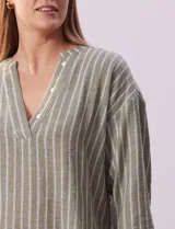 Blusa verde con rayas verticales blancas, cuello a la base y escote en V con aplique de botones. Manga ¾ con puño y botón. Tajo en costuras laterales.