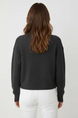 Sweater de viscosa color blanco, de tejido acanalado, con cuello redondo y calce holgado.