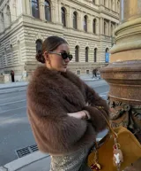 Chaqueta corta de pelo sintético color marrón, con cuello amplio y mangas abullonadas.