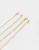 Set de dos collares cortos dorados, uno con cadena de eslabones y dijes de perlas, gotas y concha marina, y otro con mostacillas de colores.