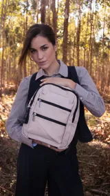 Mochila color beige de tafeta con apertura superior con cierre y tiradores metálicos. Incluye bolsillos internos, bolsillo con doble cierre metálico al frente, asas rígidas de mano y correas regulables para colgar en la espalda.