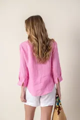 Camisa blanca de lino con cuello clásico, abotonada al frente y mangas 3/4 con puños.