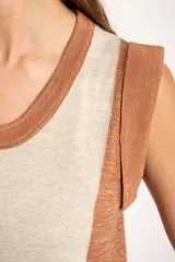 Vestido midi sin mangas, con rayas verticales en tonos naranja, beige y marrón. Confeccionado en tejido de punto suave al tacto.