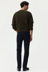 Pantalón negro de sarga de algodón, corte slim fit, con cierre de botón, bolsillos laterales, bolsillo monedero y bolsillos traseros.