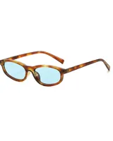 Anteojos de sol con marco ovalado color carey y lentes celestes.