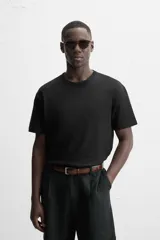 Camiseta negra de algodón de corte regular, con cuello redondo con ribete doble y mangas cortas.