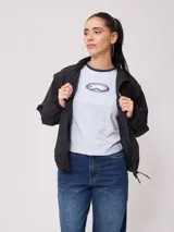 Campera negra tipo rompevientos de nylon con cierre frontal y bolsillos laterales.