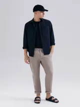 Camisa de vestir azul marino, de corte clásico, con cuello abotonado, manga larga y bolsillo en el pecho.