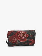 Neceser rectangular de lona color negro con estampado floral en tonos rojos y verdes. Cuenta con cierre de cremallera superior y forro interior de tactel.
