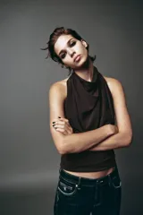Top marrón con cuello halter, escote drapeado, detalle de pliegues y cierre trasero con cremallera oculta.