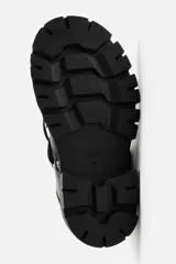 Zapato tipo derby de cuero negro con cordones y ganchos metálicos. Suela track con plataforma.