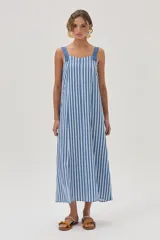 Vestido midi celeste y blanco a rayas verticales, con breteles anchos y corte recto con tajo lateral.