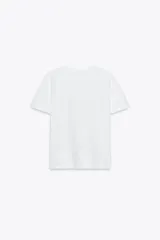 Camiseta blanca de corte recto y manga corta, con estampado frontal de una fotografía en blanco y negro y texto "Amsterdam 74".