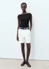 Top negro de punto con escote barco y mangas cortas. Diseño ajustado al cuerpo.