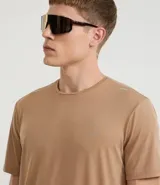 Remera deportiva de hombre, color amarillo mostaza, de manga corta y cuello redondo. Presenta un pequeño logo circular bordado en el pecho.