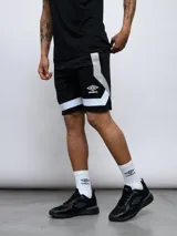 Short deportivo negro de mesh con recortes geométricos en blanco y gris. Logo de Umbro estampado en la pierna izquierda.